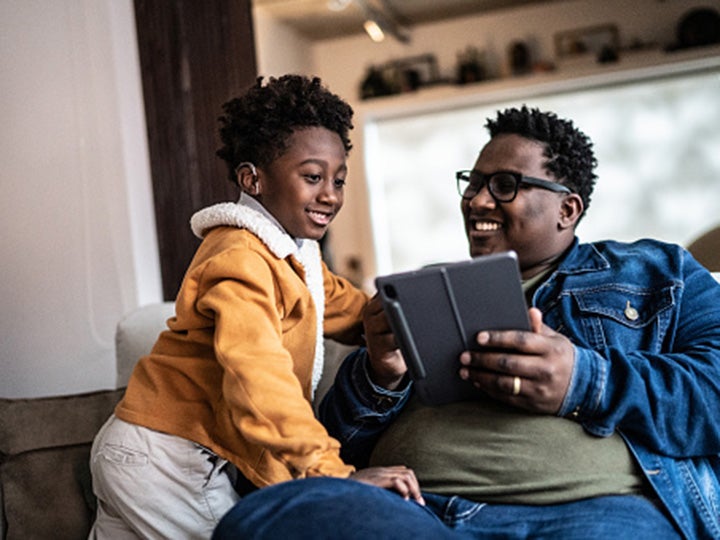 A father and son use a tablet