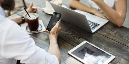 people at a table on laptops and smart phones