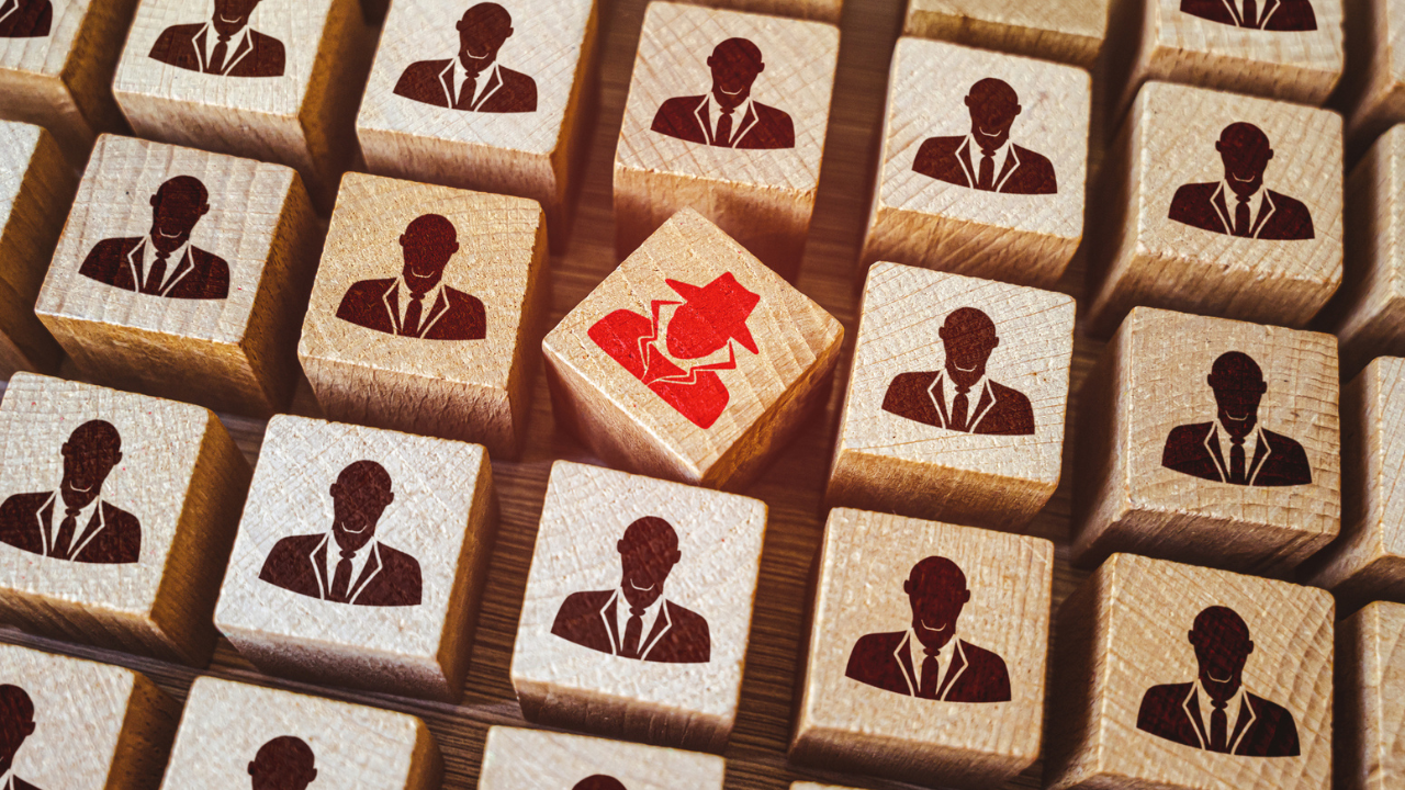 Rows of employee icons with a red imposter employee icon in the midst
